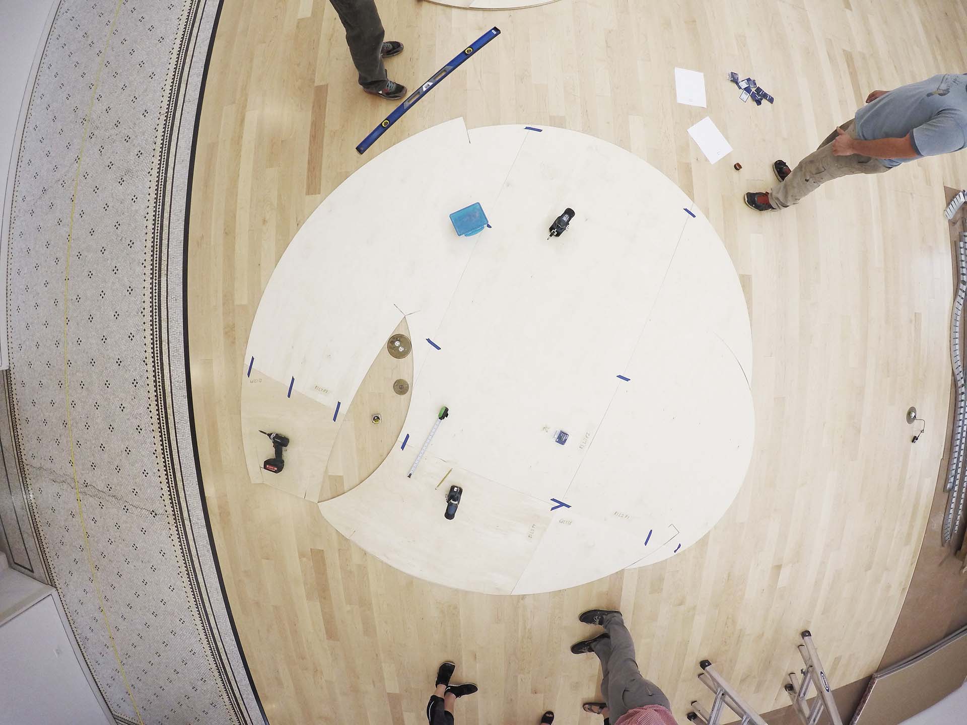 A photograph of the plywood floor plan of a room under construction, part of the gallery installation of the project The Entire Situation at the 2015 Chicago Archicture Biennial.